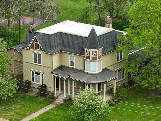 435 Jefferson St, Eau Claire, WI 54701 - rear view of property with a chimney, roof with shingles, and a lawn