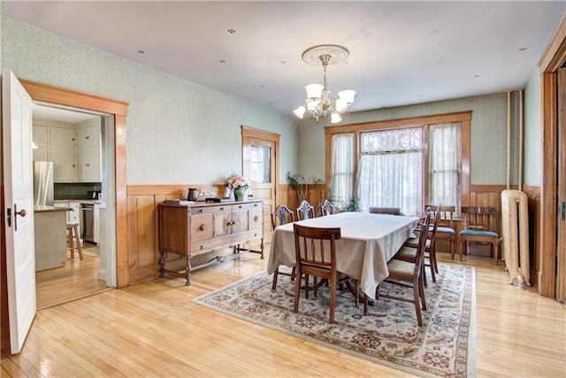 435 Jefferson St, Eau Claire, WI 54701 - dining area featuring wallpapered walls, wainscoting, a chandelier, radiator, and light wood-type flooring