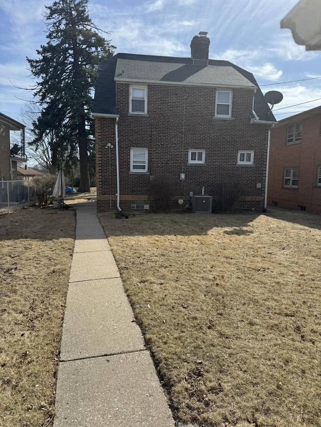 7126 W Congress St, Milwaukee, WI 53218 - view of side of property with roof with shingles, brick siding, central AC, and a chimney