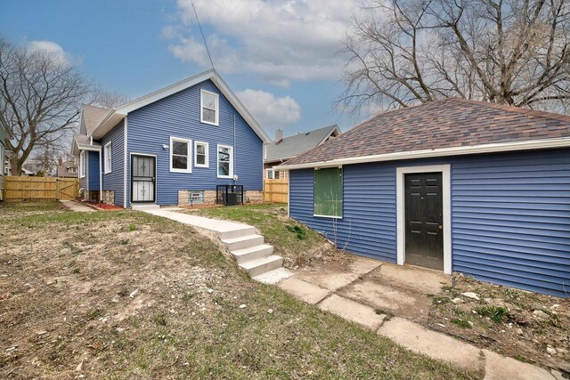 back of property featuring cooling unit and fence