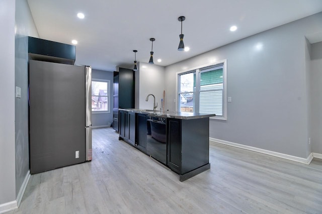 kitchen with dark cabinets, light wood-style flooring, freestanding refrigerator, pendant lighting, and dishwasher