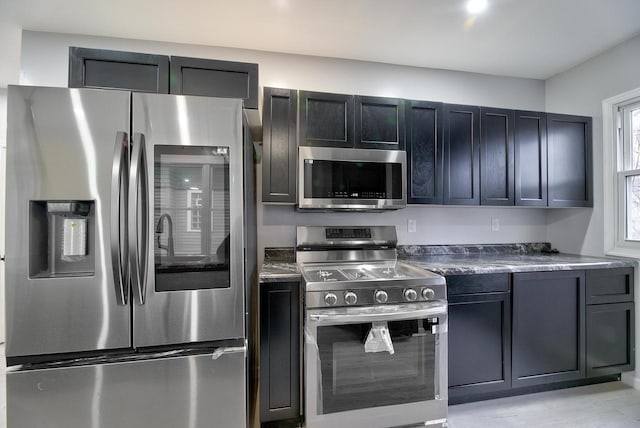 kitchen with stainless steel appliances and dark countertops