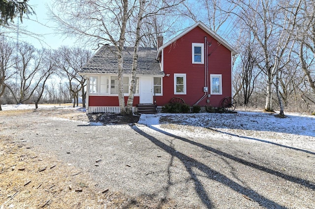 view of front of property featuring a shingled roof and a chimney