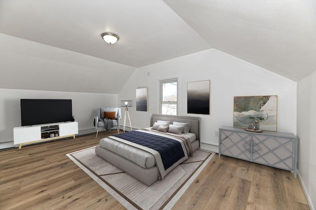 bedroom featuring vaulted ceiling, wood finished floors, and baseboard heating
