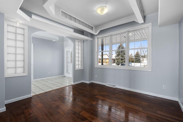 2155 Cottonwood Dr, Menasha, WI 54952 - unfurnished room with visible vents, arched walkways, baseboards, and wood-type flooring