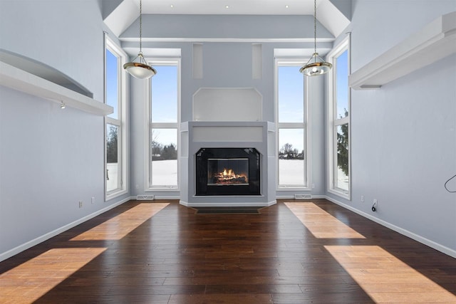 2155 Cottonwood Dr, Menasha, WI 54952 - unfurnished living room featuring hardwood / wood-style flooring, a wealth of natural light, baseboards, and a towering ceiling
