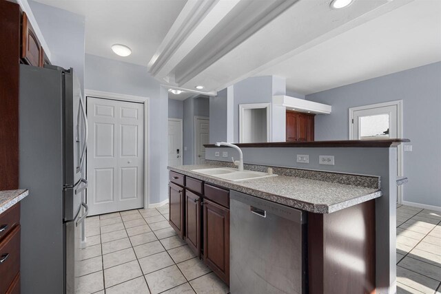 2155 Cottonwood Dr, Menasha, WI 54952 - kitchen featuring light tile patterned floors, stainless steel appliances, an island with sink, and a sink