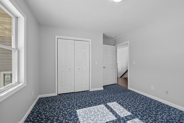 2155 Cottonwood Dr, Menasha, WI 54952 - unfurnished bedroom with a closet, carpet flooring, and baseboards