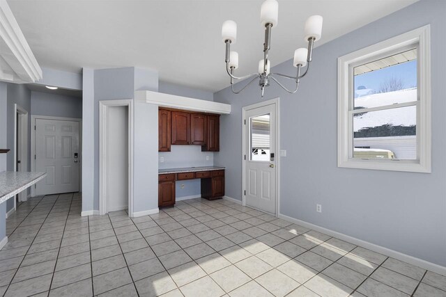 2155 Cottonwood Dr, Menasha, WI 54952 - kitchen featuring light countertops, a notable chandelier, light tile patterned flooring, and baseboards