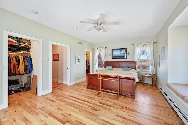 6112 County Road A, Brooklyn, WI 53521 - bedroom with light wood-style flooring, a walk in closet, a baseboard radiator, and baseboard heating