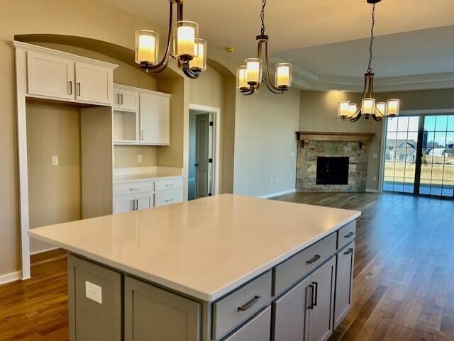 kitchen with a chandelier, dark wood finished floors, gray cabinetry, and a center island