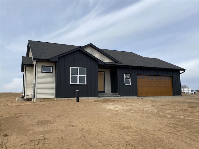 4607 933rd St, Elk Mound, WI 54739 - view of front facade with board and batten siding, an attached garage, and a shingled roof