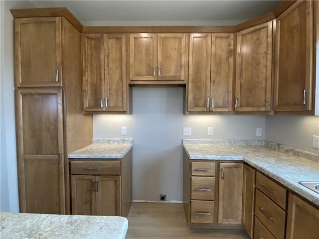 4607 933rd St, Elk Mound, WI 54739 - kitchen featuring light wood-style floors, brown cabinets, and light countertops