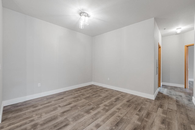 unfurnished room featuring wood finished floors and baseboards
