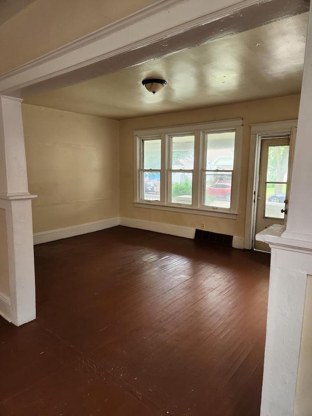 4047 N 19th St Unit 4049, Milwaukee, WI 53209 - unfurnished living room featuring decorative columns, baseboards, and dark wood-style floors