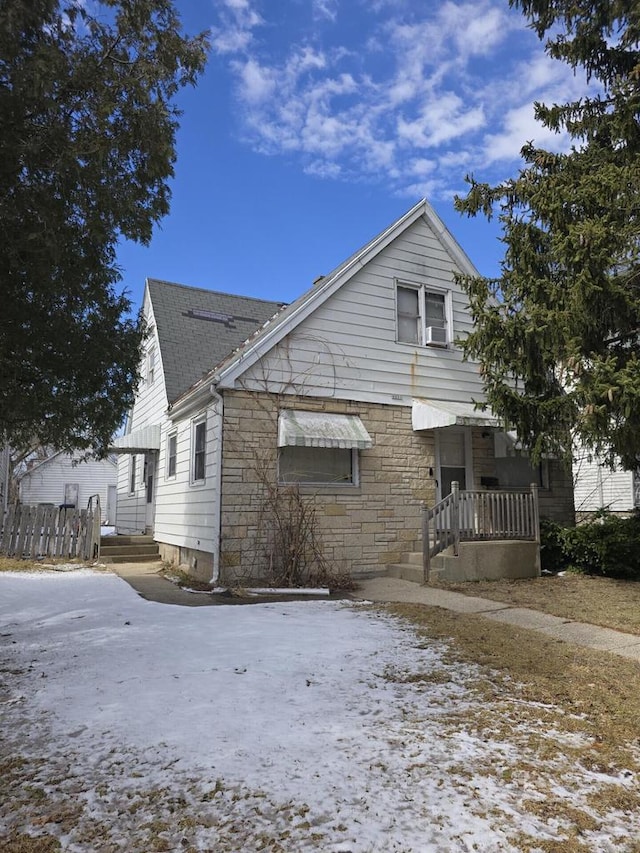 view of front of home with stone siding and a shingled roof