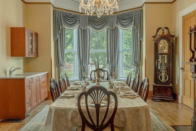 1222 11th St, Monroe, WI 53566 - dining room with a chandelier, light wood-style flooring, crown molding, and baseboards