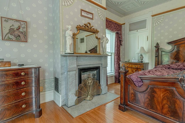 1222 11th St, Monroe, WI 53566 - bedroom with wallpapered walls, wood finished floors, and a glass covered fireplace