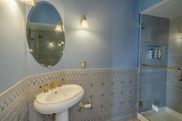 1222 11th St, Monroe, WI 53566 - full bathroom with tile walls, a shower stall, a sink, and wainscoting