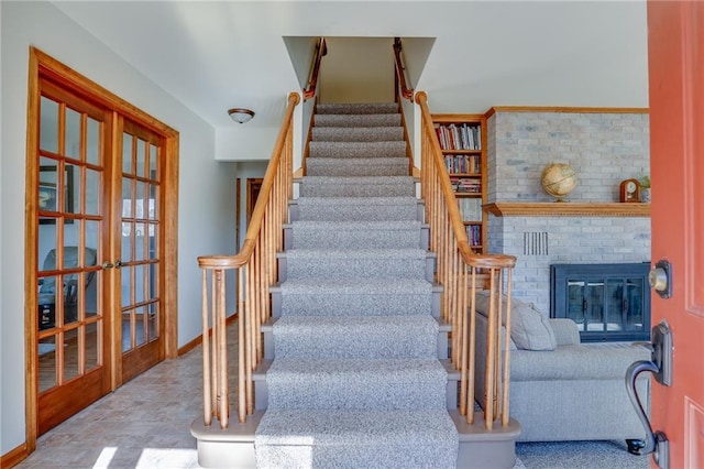 1353 Van Buren St, Black River Falls, WI 54615 - stairway featuring french doors, baseboards, and a fireplace