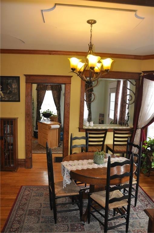 13600 8th St, Osseo, WI 54758 - dining space with a chandelier, crown molding, and wood finished floors