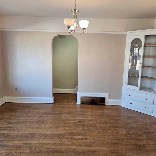 3731 S 56th St, Greenfield, WI 53220 - unfurnished dining area with visible vents, baseboards, wood finished floors, arched walkways, and a notable chandelier