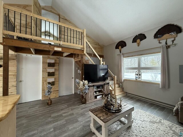 6955 Kolling Rd, Iron River, WI 54847 - living room with high vaulted ceiling, a baseboard heating unit, stairs, and wood finished floors