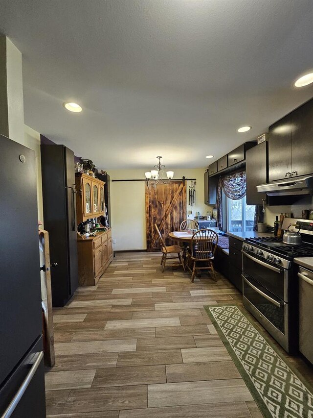 1159 Dover Dr, Adams, WI 53910 - kitchen featuring stainless steel appliances, recessed lighting, under cabinet range hood, wood tiled floor, and an inviting chandelier