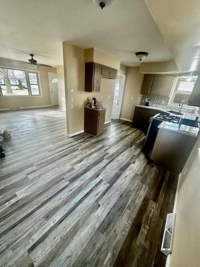 7140 N 48th St, Milwaukee, WI 53223 - kitchen with baseboards, open floor plan, a ceiling fan, wood finished floors, and backsplash