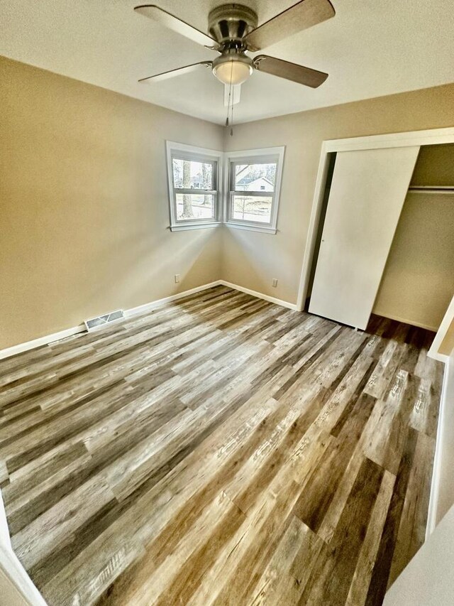 7140 N 48th St, Milwaukee, WI 53223 - unfurnished bedroom with a closet, a ceiling fan, visible vents, wood finished floors, and baseboards