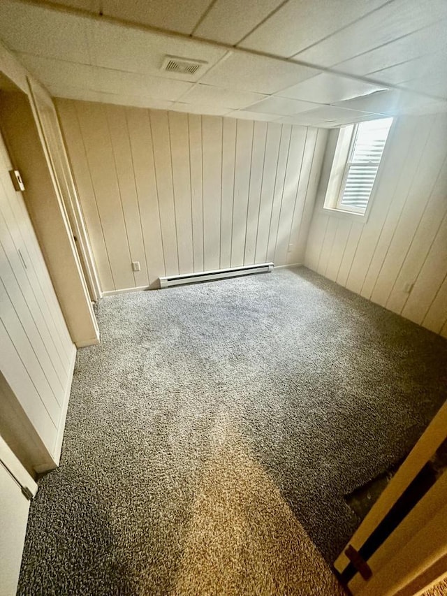 7140 N 48th St, Milwaukee, WI 53223 - empty room featuring a baseboard heating unit, visible vents, wooden walls, and carpet