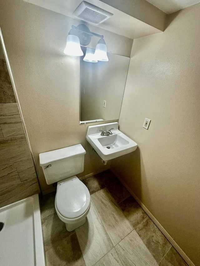 7140 N 48th St, Milwaukee, WI 53223 - bathroom with visible vents, baseboards, a sink, toilet, and a shower