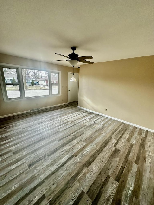 7140 N 48th St, Milwaukee, WI 53223 - unfurnished living room featuring wood finished floors, baseboards, a ceiling fan, and visible vents