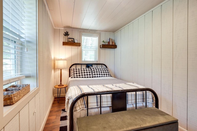 bedroom with baseboards, wood finished floors, and wood ceiling