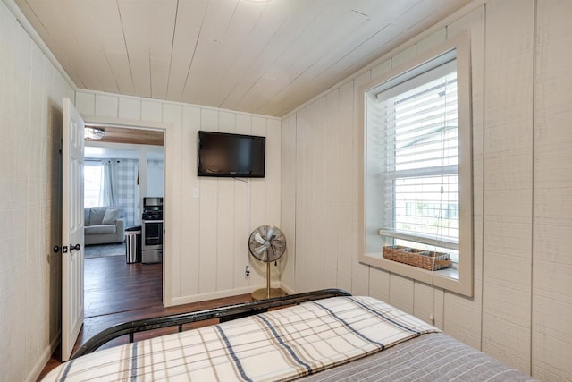 bedroom with wooden ceiling, multiple windows, and wood finished floors