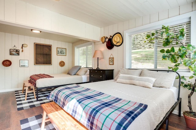 bedroom featuring dark wood-type flooring, baseboards, and multiple windows
