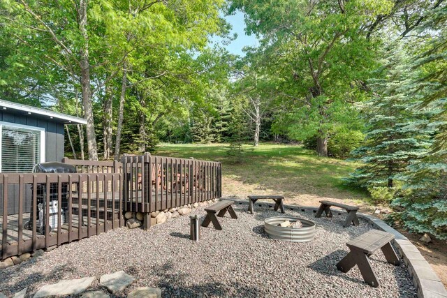 view of yard featuring an outdoor fire pit and a wooden deck