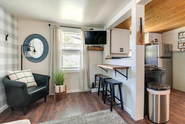 sitting room with dark wood-type flooring and baseboards