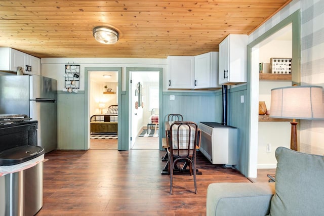kitchen featuring white cabinetry, gas range, wood ceiling, dark wood-style floors, and freestanding refrigerator