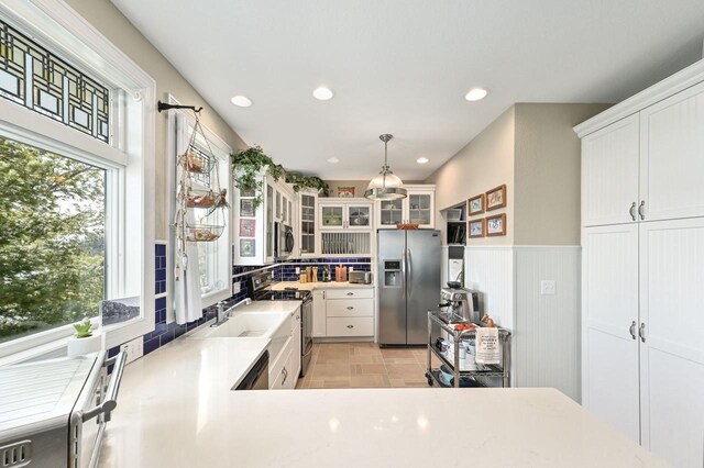 N8512 Booth Lake Heights Rd, East Troy, WI 53120 - kitchen with a wainscoted wall, white cabinets, recessed lighting, appliances with stainless steel finishes, and glass insert cabinets