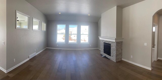 3371 Capellla Ln, Green Bay, WI 54311 - unfurnished living room with a fireplace, baseboards, visible vents, arched walkways, and dark wood-style flooring