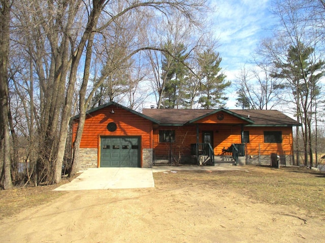 207 E Water St, Montello, WI 53949 - rustic home featuring stone siding, dirt driveway, a garage, and faux log siding