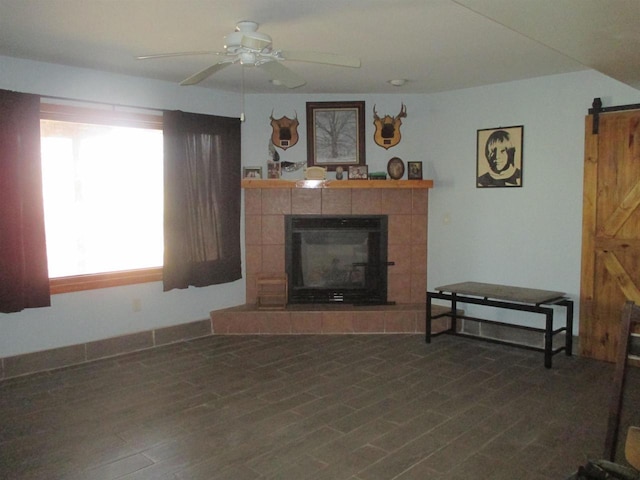 207 E Water St, Montello, WI 53949 - living room featuring a tiled fireplace, ceiling fan, and a barn door