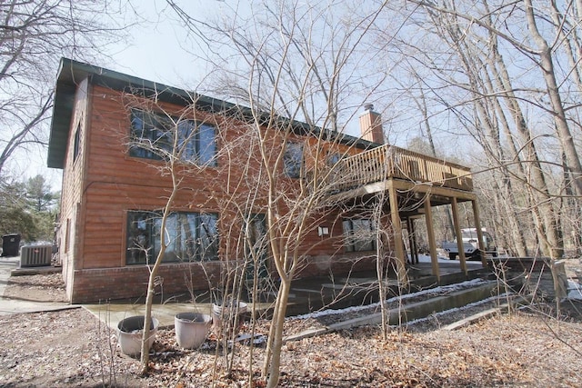 207 E Water St, Montello, WI 53949 - view of property exterior with a wooden deck, a chimney, and central AC