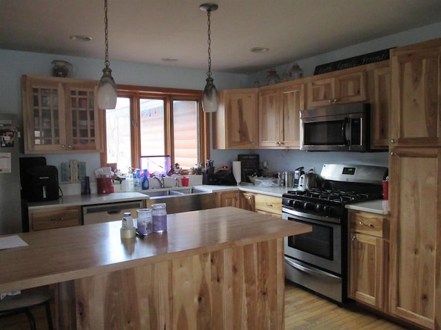 207 E Water St, Montello, WI 53949 - kitchen with appliances with stainless steel finishes, a sink, wooden counters, light wood-style flooring, and glass insert cabinets