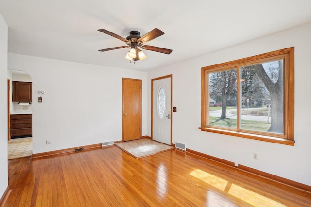 1301 Wyldhaven Ave, Monona, WI 53716 - interior space with visible vents, light wood-style flooring, a ceiling fan, and arched walkways