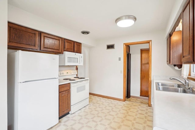 1301 Wyldhaven Ave, Monona, WI 53716 - kitchen with white appliances, light floors, visible vents, light countertops, and a sink