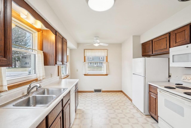 1301 Wyldhaven Ave, Monona, WI 53716 - kitchen with white appliances, a wealth of natural light, visible vents, light floors, and a sink