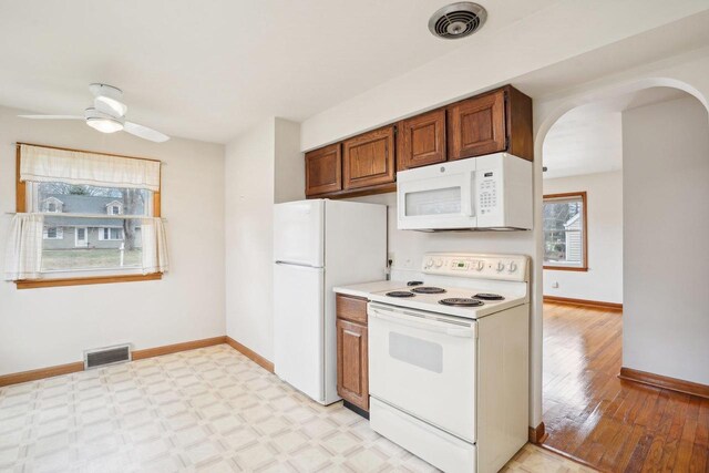 1301 Wyldhaven Ave, Monona, WI 53716 - kitchen with visible vents, baseboards, arched walkways, and white appliances