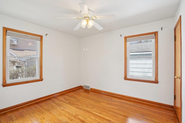 1301 Wyldhaven Ave, Monona, WI 53716 - empty room featuring light wood-style flooring, visible vents, baseboards, and ceiling fan